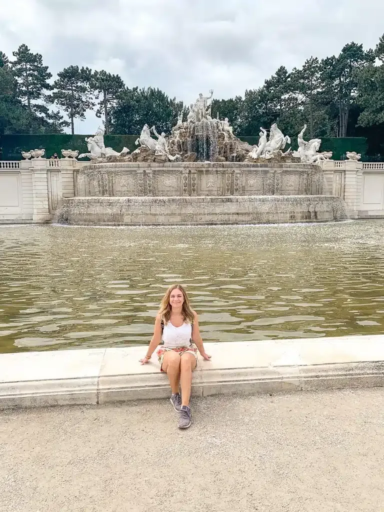 author sitting in front of fountain 