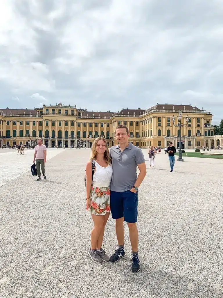 author and her husband in vienna standing in front of famous castle schoenbrunn