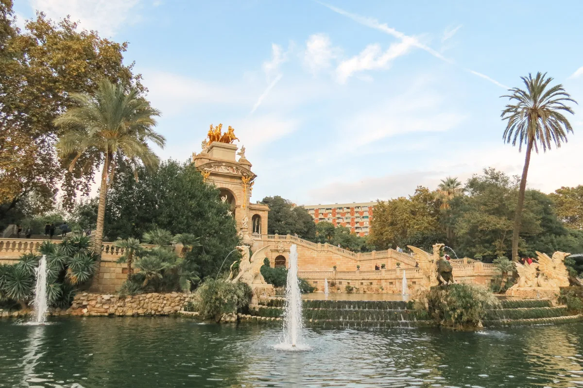 The grand Cascada Fountain at Parc de la Ciutadella in Barcelona, with lush greenery, ornate sculptures, and a golden quadriga on top.