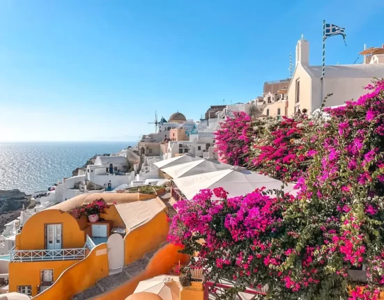 santorini oia view with colorful flowers and orange houses
